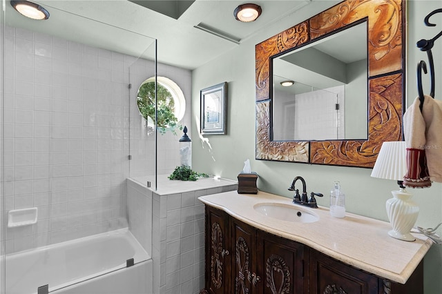 bathroom featuring tiled shower / bath and vanity