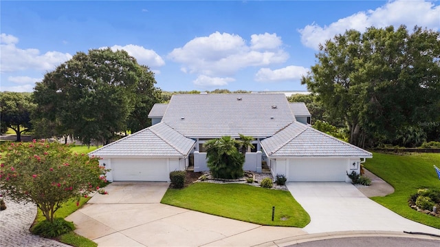 ranch-style house with a garage and a front lawn