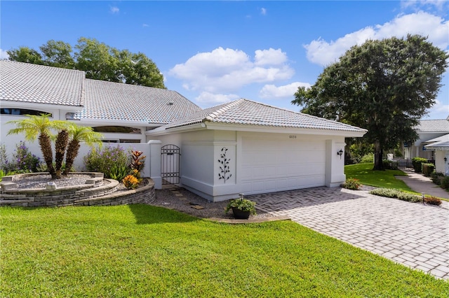 mediterranean / spanish house with a garage and a front lawn