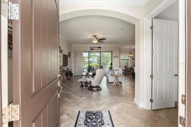 entrance foyer featuring ceiling fan, crown molding, and light tile patterned flooring