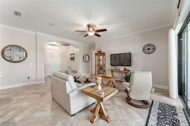 tiled living room with ceiling fan and crown molding