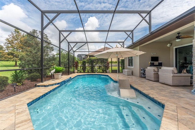 view of swimming pool featuring glass enclosure, ceiling fan, a patio, and pool water feature