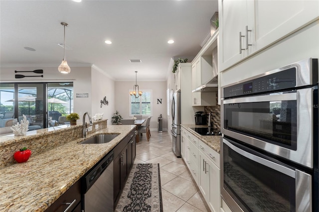 kitchen with appliances with stainless steel finishes, a healthy amount of sunlight, sink, and white cabinets