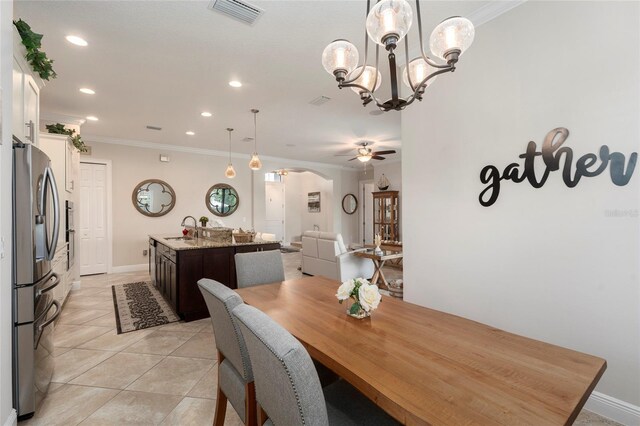 dining space featuring ornamental molding, ceiling fan with notable chandelier, sink, and light tile patterned flooring