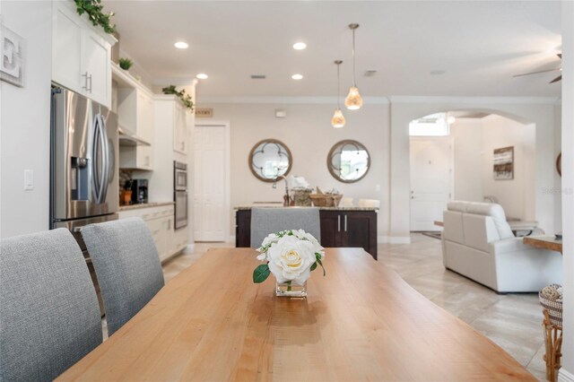 dining room featuring ceiling fan, ornamental molding, and sink