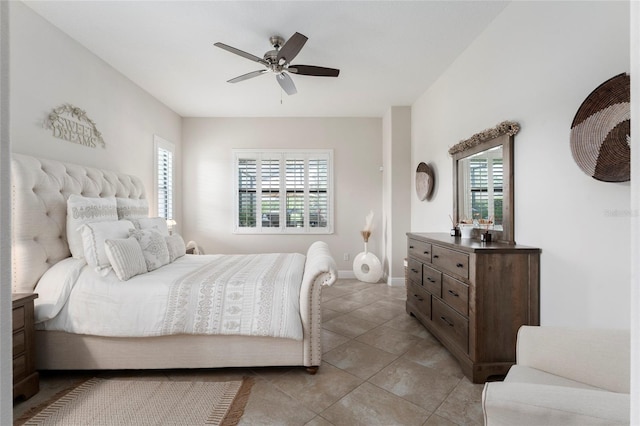 tiled bedroom with ceiling fan and multiple windows