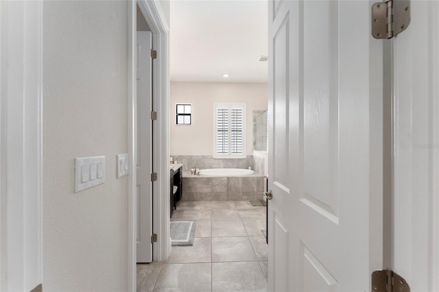 bathroom featuring tile patterned flooring and a relaxing tiled tub