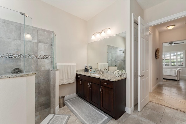 bathroom featuring tile patterned flooring, ceiling fan, a tile shower, and vanity