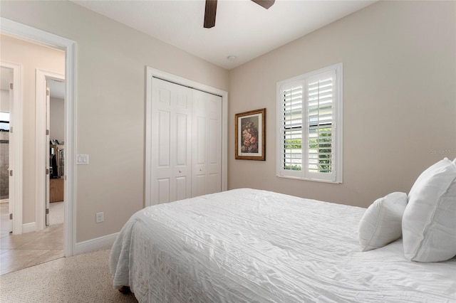 tiled bedroom with ceiling fan and a closet