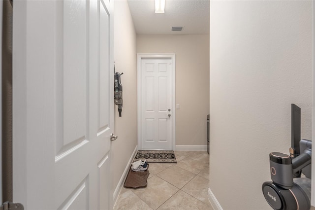 interior space with a textured ceiling and tile patterned floors