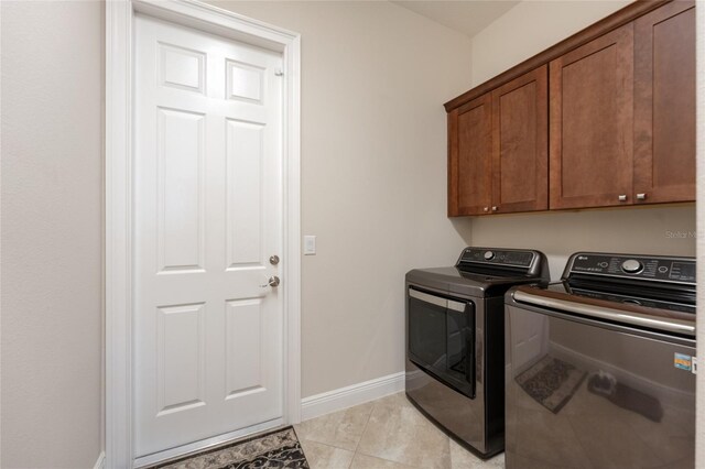 laundry room with cabinets, light tile patterned floors, and independent washer and dryer