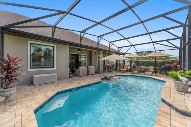 view of pool with pool water feature, ceiling fan, a patio area, and a lanai