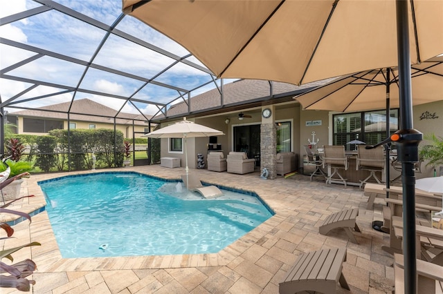 view of swimming pool with a patio area, an outdoor bar, glass enclosure, ceiling fan, and an outdoor kitchen