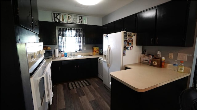 kitchen featuring stainless steel appliances, dark hardwood / wood-style floors, sink, and kitchen peninsula