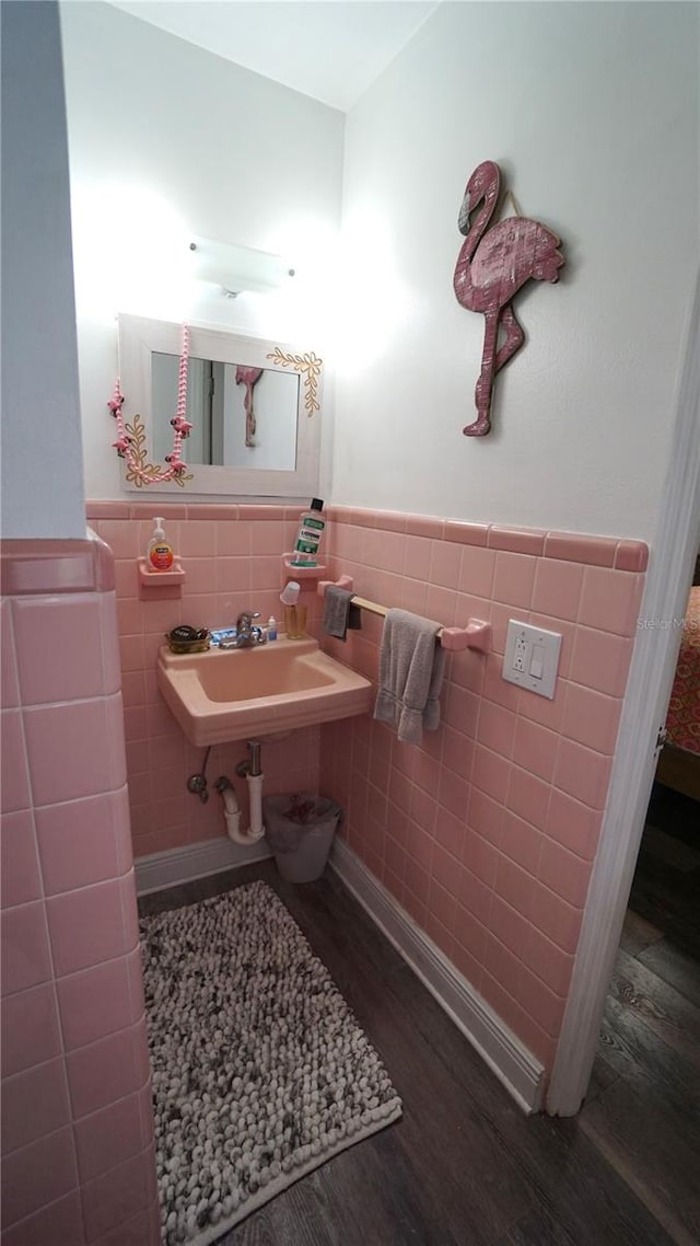 bathroom with hardwood / wood-style floors, tile walls, tasteful backsplash, and sink