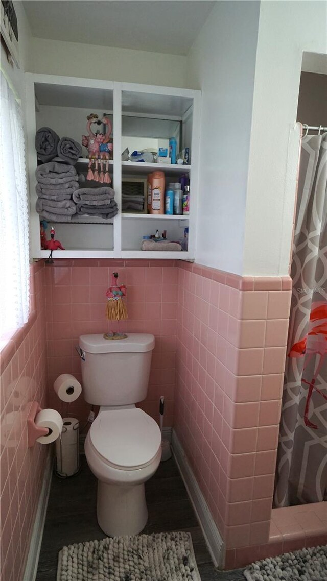 bathroom featuring tile walls, toilet, curtained shower, and wood-type flooring