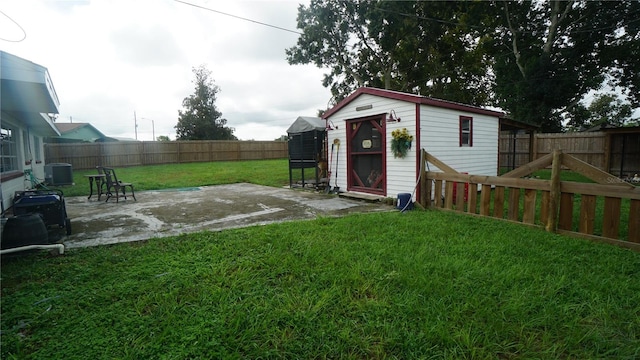 view of yard with a patio, central AC, and a storage unit