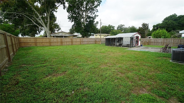 view of yard featuring central AC and a storage shed