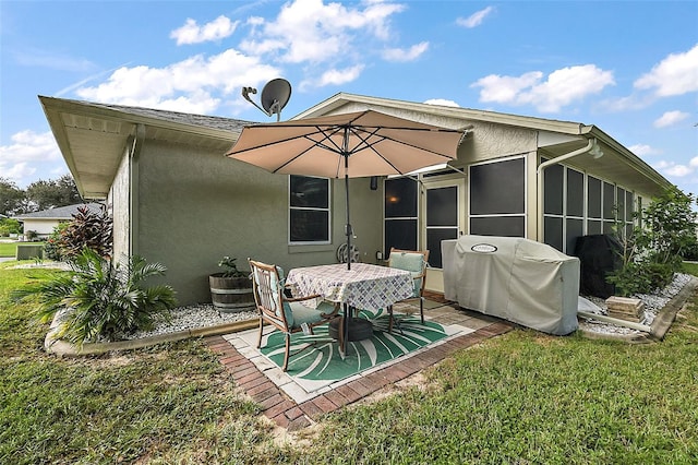 back of property with a yard and a patio