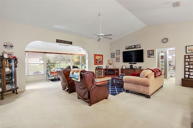 living room featuring ceiling fan, a textured ceiling, lofted ceiling, and carpet