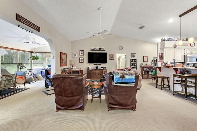 carpeted living room with lofted ceiling, ceiling fan, and a textured ceiling