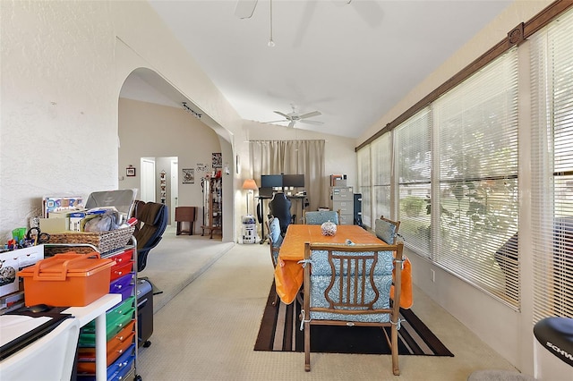 dining space with vaulted ceiling, ceiling fan, and light colored carpet