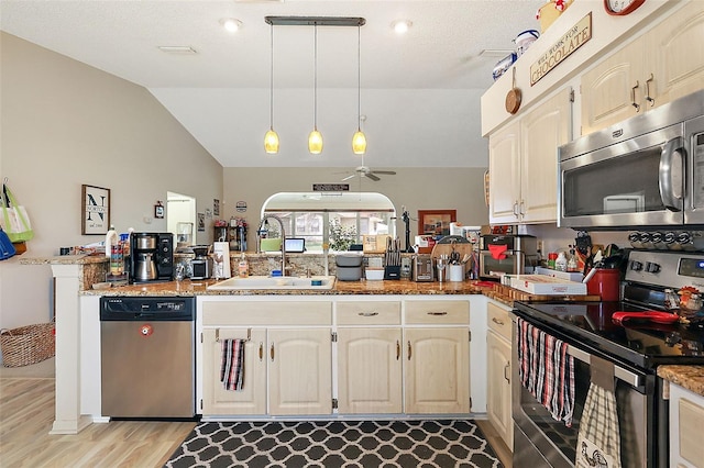 kitchen featuring pendant lighting, sink, kitchen peninsula, stainless steel appliances, and ceiling fan