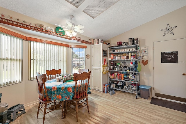 dining space featuring light wood-type flooring, a textured ceiling, and ceiling fan