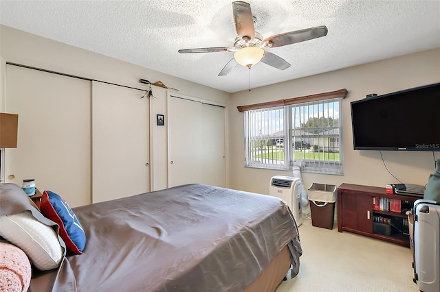 carpeted bedroom with ceiling fan and a textured ceiling