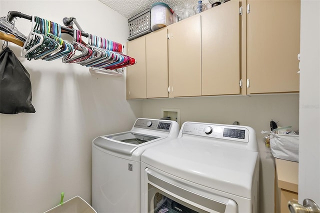 washroom with cabinets, a textured ceiling, and washer and dryer