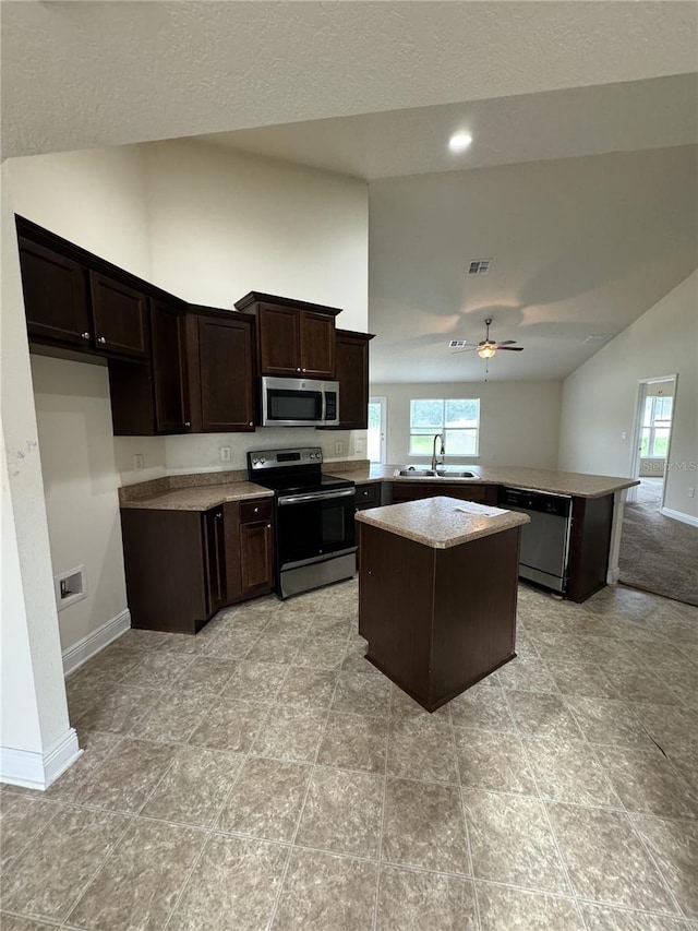 kitchen with appliances with stainless steel finishes, a center island, kitchen peninsula, sink, and ceiling fan