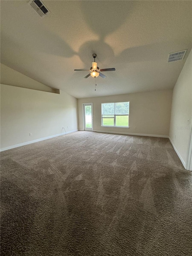 carpeted empty room with ceiling fan, vaulted ceiling, and a textured ceiling