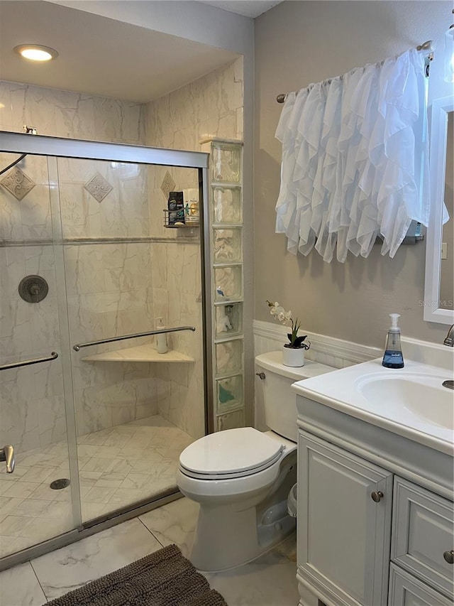 bathroom with vanity, toilet, and a shower with shower door