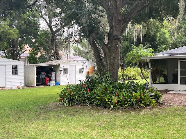 view of yard with a sunroom and a storage unit