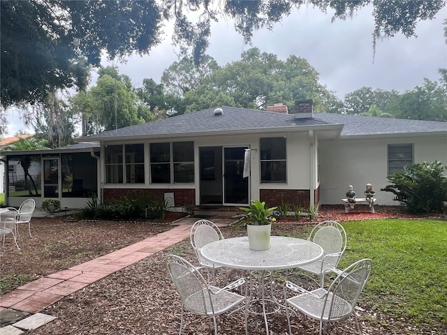 back of house with a lawn and a sunroom