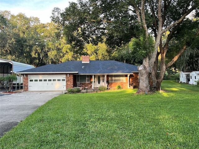 single story home featuring a garage, a porch, a front lawn, and a carport