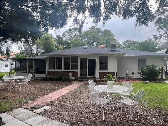 back of house featuring a yard and a sunroom