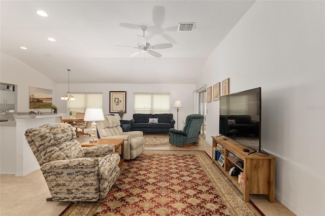 living room with ceiling fan with notable chandelier and vaulted ceiling