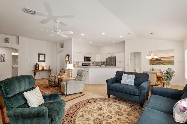 living room with ceiling fan with notable chandelier and vaulted ceiling