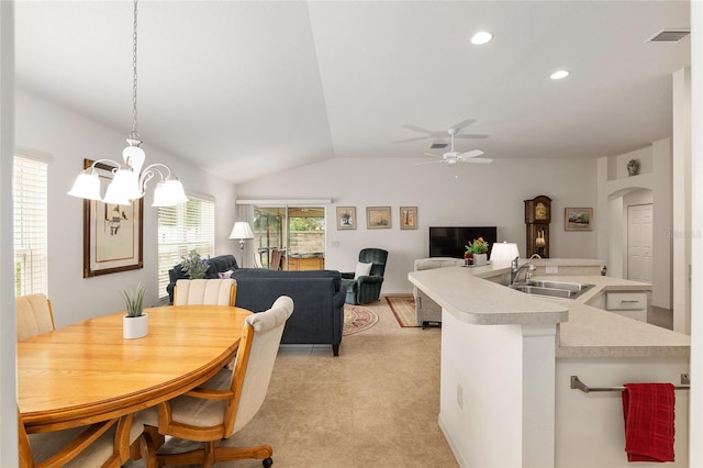 dining room featuring vaulted ceiling, ceiling fan with notable chandelier, and sink