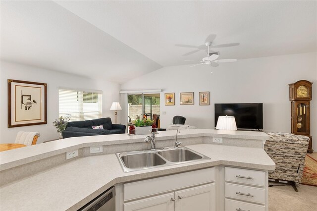 kitchen featuring ceiling fan, sink, white cabinetry, vaulted ceiling, and light colored carpet