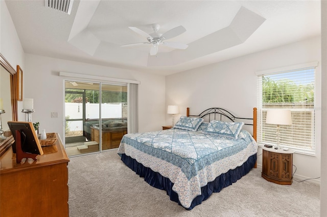 bedroom featuring carpet flooring, ceiling fan, and a raised ceiling