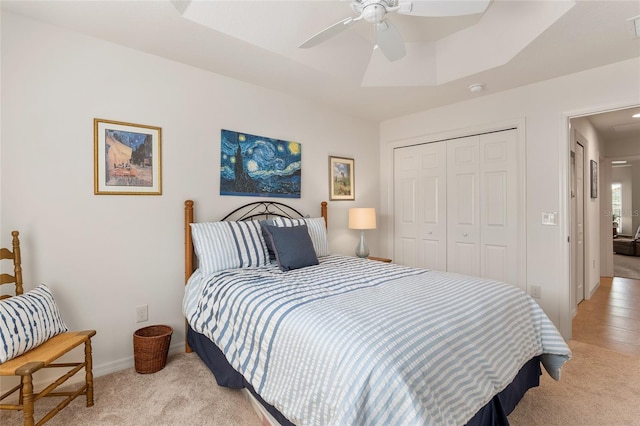 carpeted bedroom featuring ceiling fan and a closet