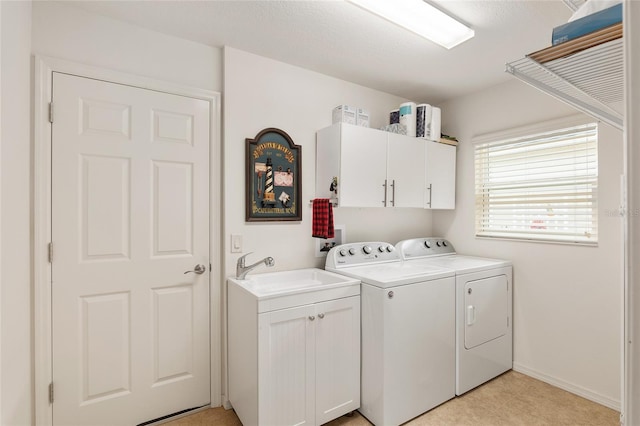 washroom with washer and clothes dryer, cabinets, and sink