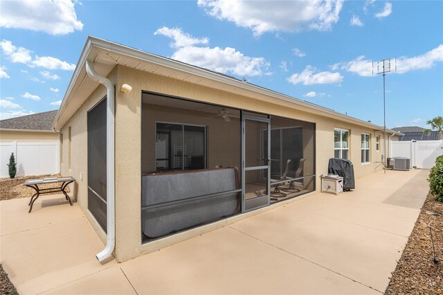 rear view of house featuring a patio, a sunroom, central AC, and ceiling fan