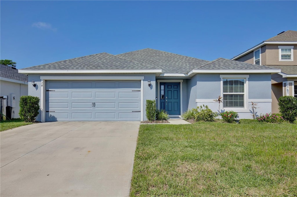 ranch-style house with a garage and a front lawn