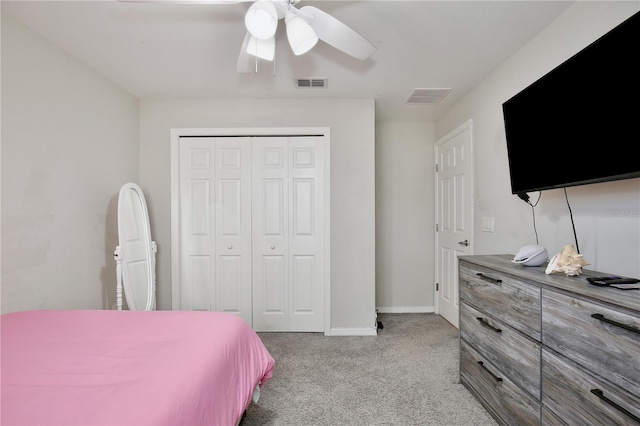 bedroom featuring a closet, light colored carpet, and ceiling fan