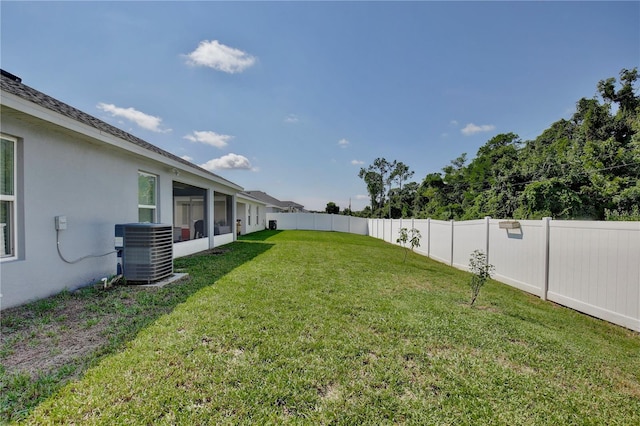 view of yard featuring a sunroom and central air condition unit