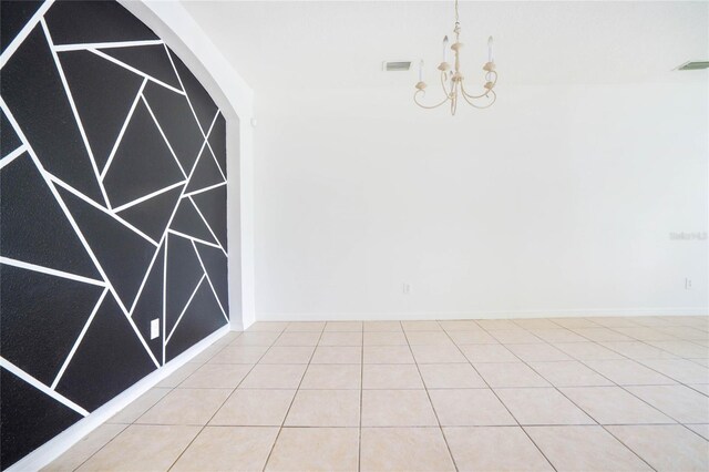 tiled empty room with a chandelier