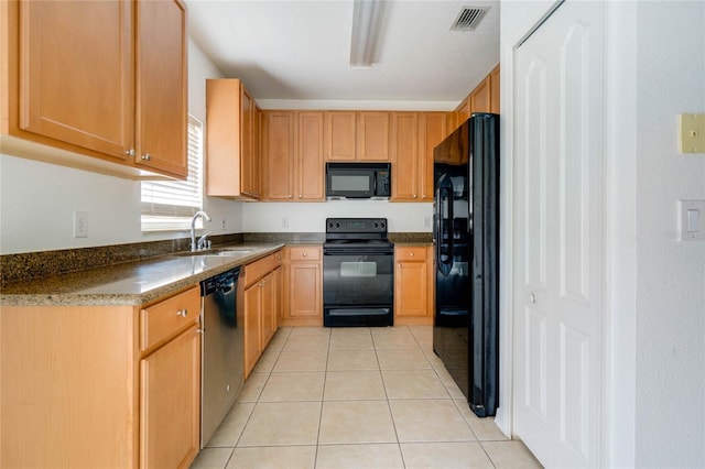 kitchen with black appliances, sink, and light tile patterned floors